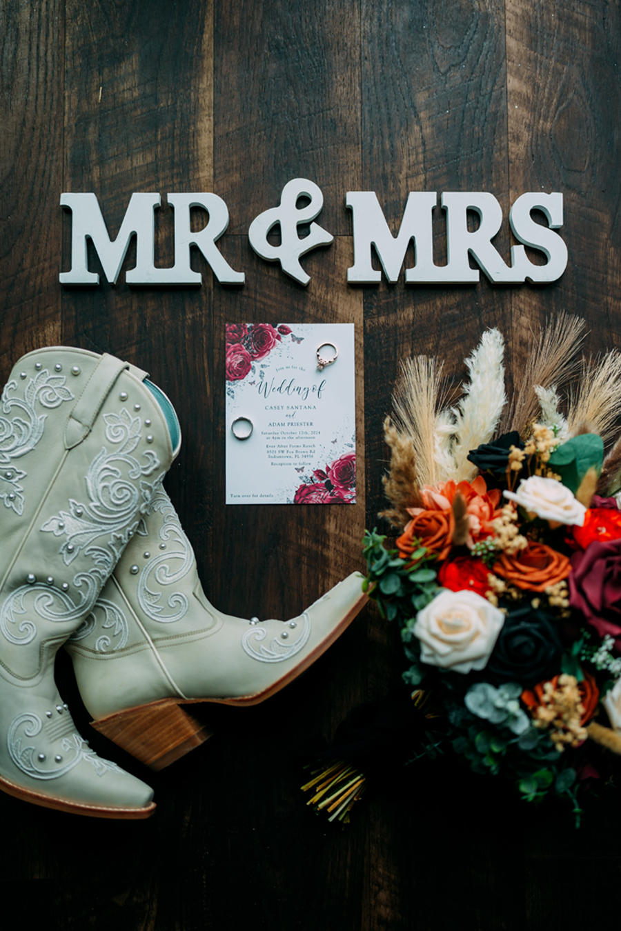 Wedding boots, bouquet, rings, and invitations at Ever After Farms Ranch wedding